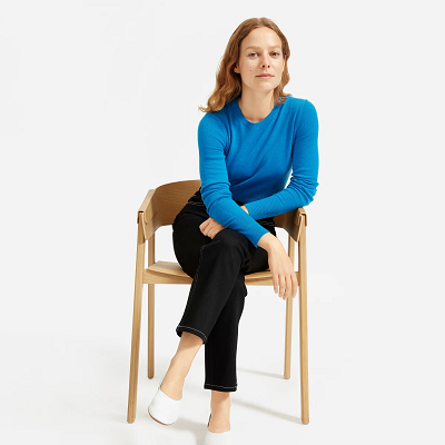 woman sitting on a stool in a blue sweater