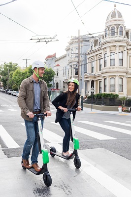 man and woman riding electric scooter