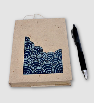 handmade paper journal with pen next to it