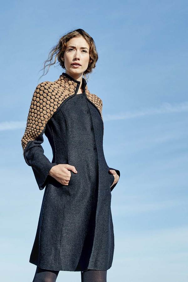 White woman standing against a blue sky wearing a Knit and Boiled Alpaca Wool Coat