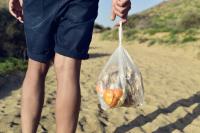 holding a plastic bag of compost