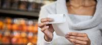 Image: woman holding paper receipt Topic: Skip the Slip to reduce store receipts