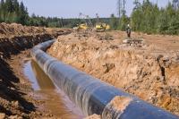 workers construct gas pipeline over groundwater