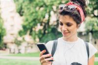 girl standing outside listening to a podcast