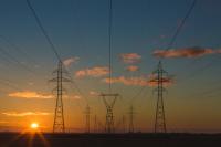 Sunset behind power lines and towers, which do not prioritize energy efficiency