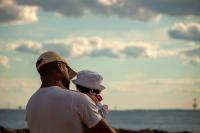 Black dad and daughter looking towards the bay