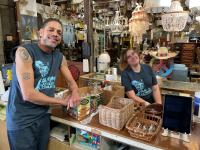 Two Community Forklift employees standing at the register and smiling at the camera.