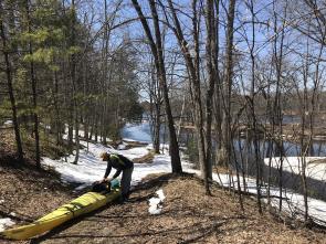 man pulls kayak out of Menominee offshoot