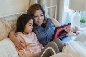 mother and daughter looking at a tablet together and talking