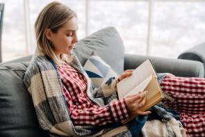 woman reading in red checkered pajamas