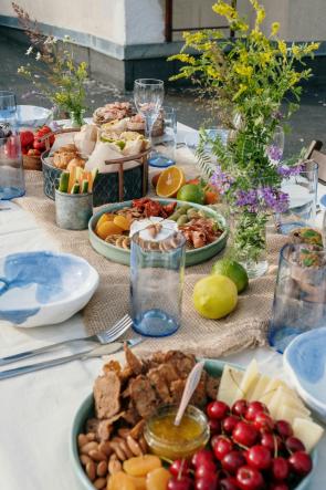 A spread of vegetables, herbs, fruit on a set table