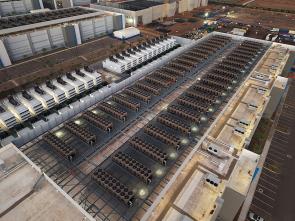 Aerial view of a large data center rooftop covered with rows of industrial cooling units.