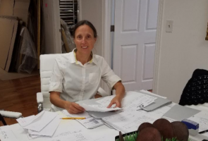 Business Owner, Susan Walko, sitting at a kitchen table organizing paperwork.