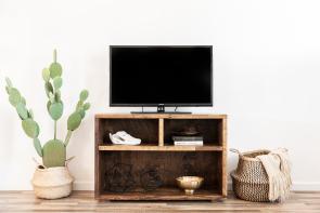 Simple well-made media unit with three cubbies surrounded by southwestern decor items 