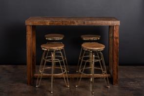 Well-made counter height real wood table in a deep stain color accompanied by four metal and wood stools