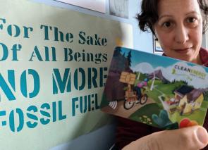 Image: Woman holding a card that reads "clean energy"