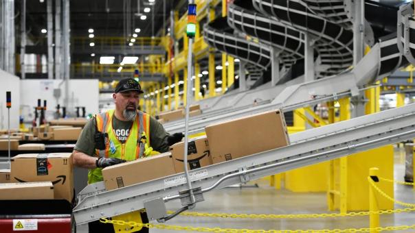 man working in Amazon plant with packages