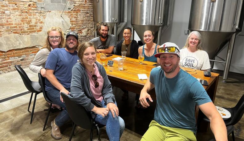 Brian James and Green America team members sitting around a table at a brewery.