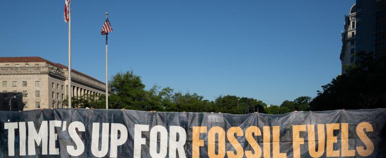 The 2021 J30 climate protest in Washington, DC. Groups gather with a sign that read "time's up for fossil fuels," protesting things like anti-ESG bills.