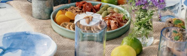 A spread of vegetables, herbs, fruit on a set table