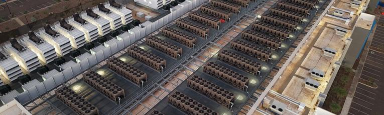 Aerial view of a large data center rooftop covered with rows of industrial cooling units.