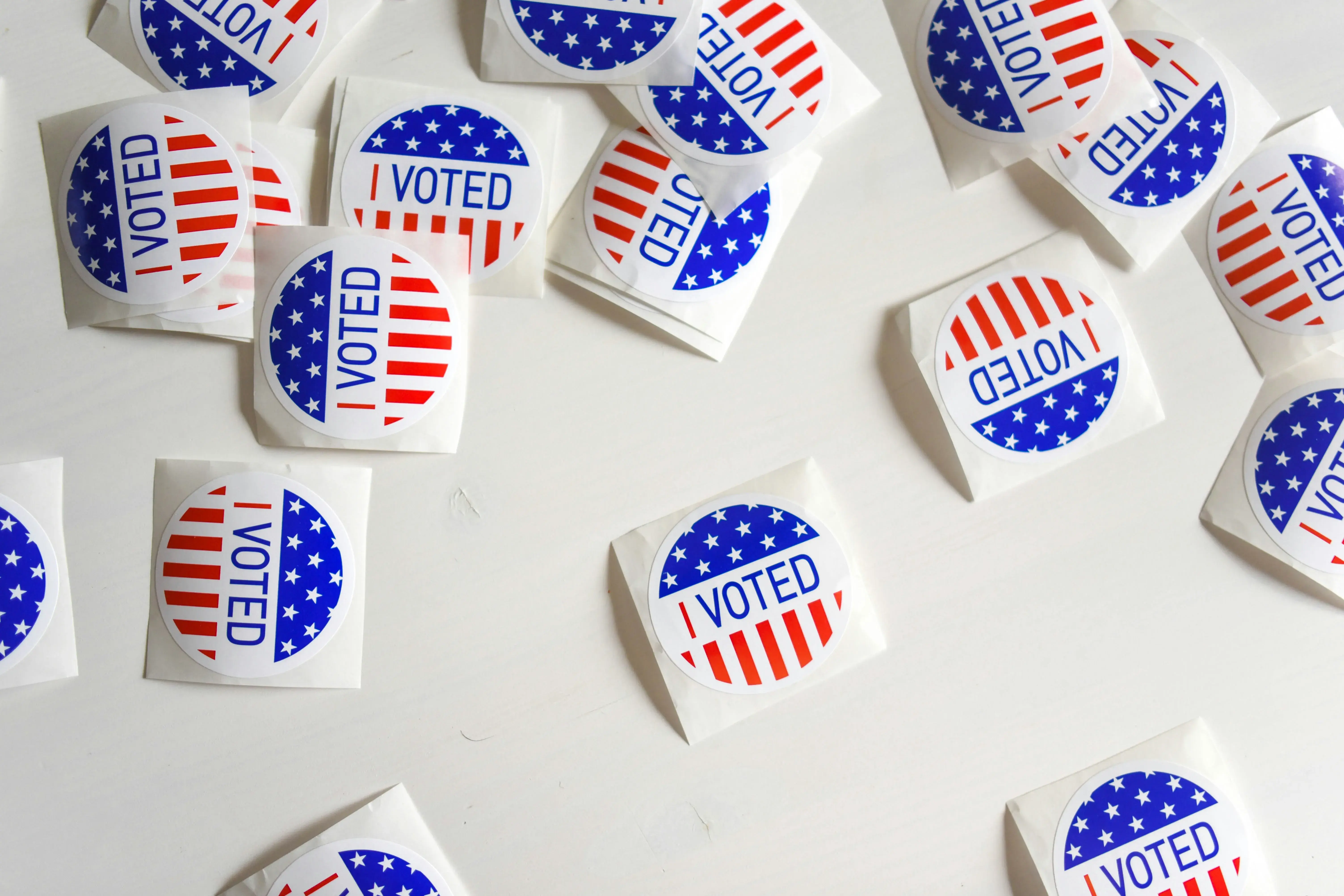 Stickers that read "I Voted" scattered across a white table top.