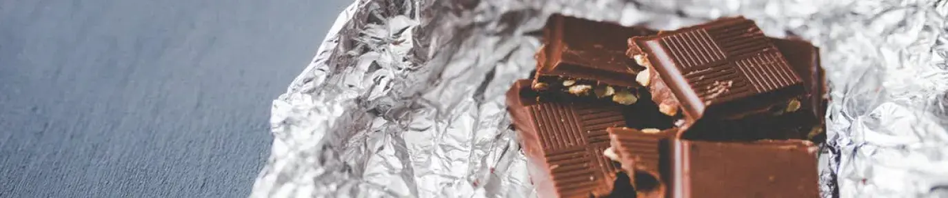 Image: chocolate in tinfoil wrapper. Title: Spotlight on Hershey and Child Labor, Two Years Later