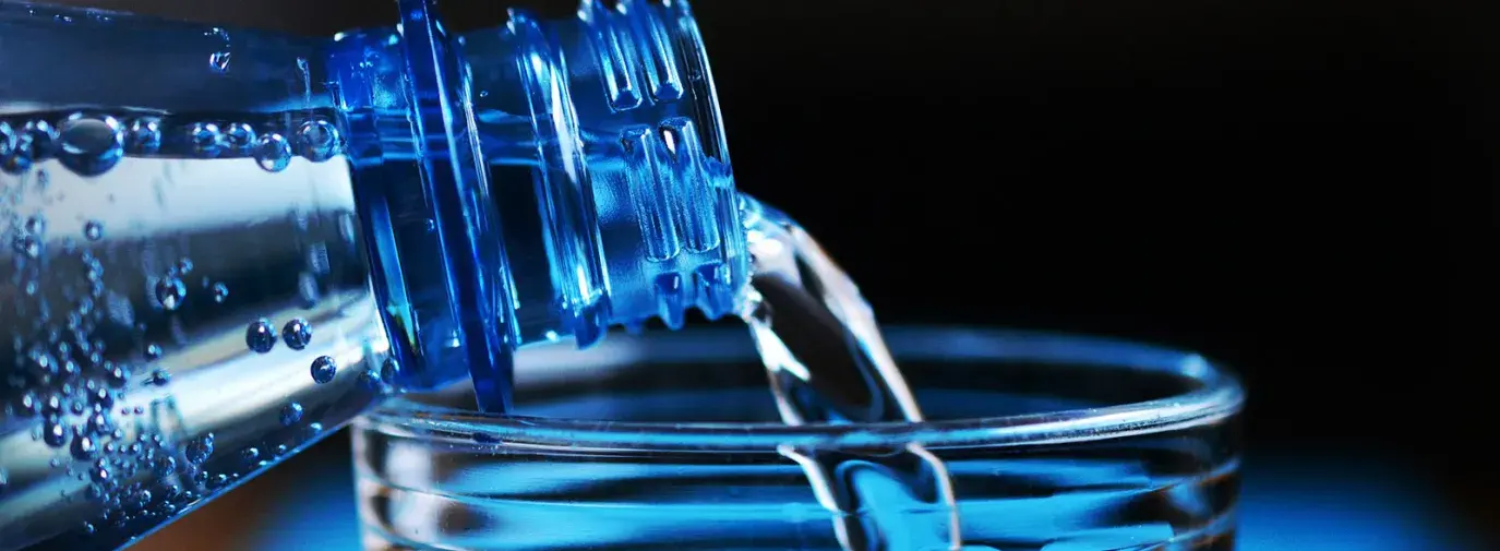 Image: water being poured from a bottle into a glass. Title: Why Bottled Water Isn’t Better