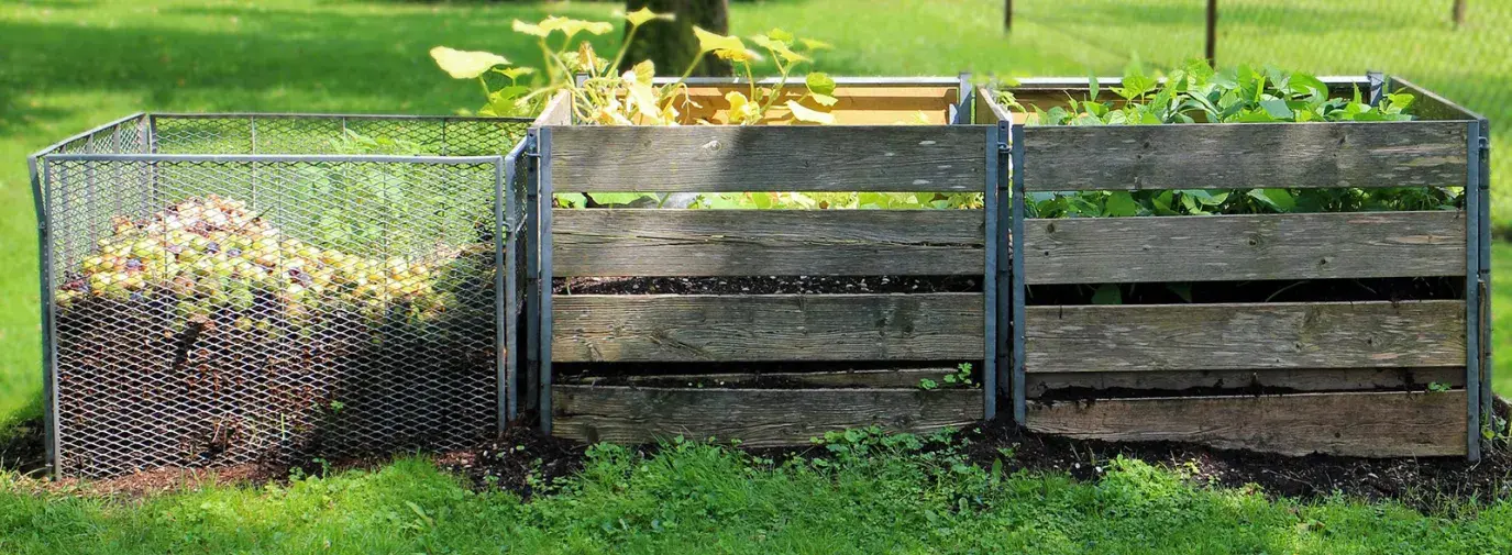 Image: three compost bins in a yard. Topic: 6 Popular Composting Options
