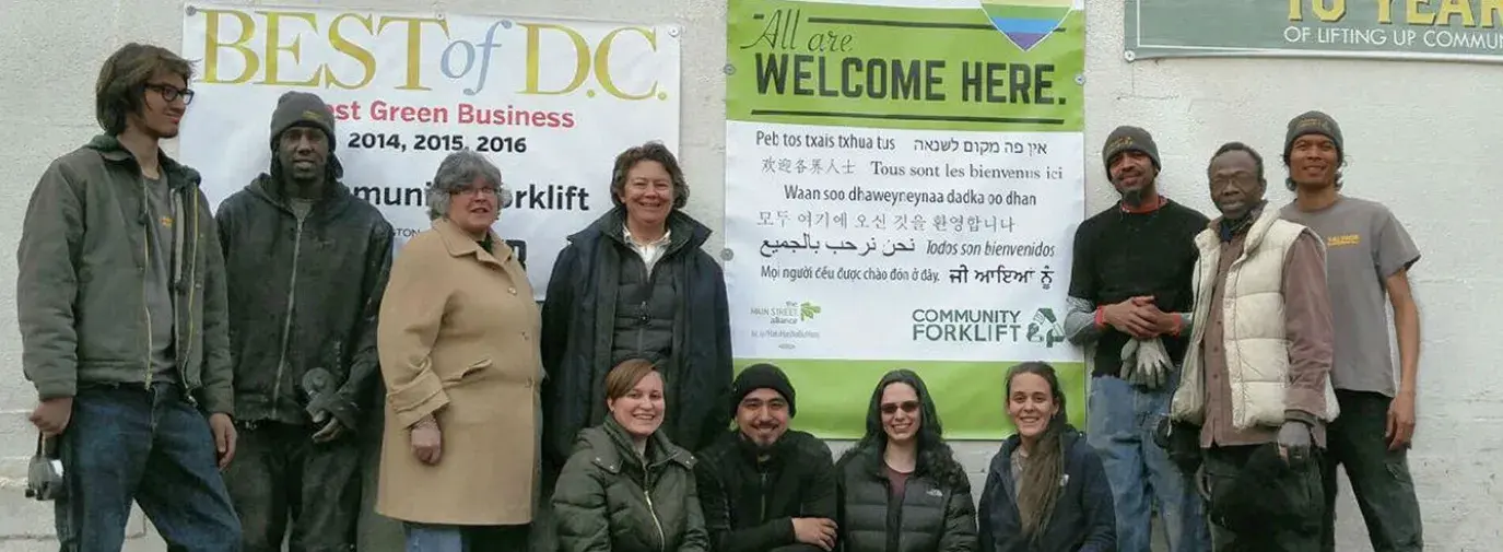 The Main Street Alliance is urging businesses nationwide to print out and display its anti-hate posters in their offices and shop-fronts. Community Forklift turned theirs into a huge banner, seen here hagning in front of their Maryland warehouse store with several employees. Photo courtesy of Community Forklift.