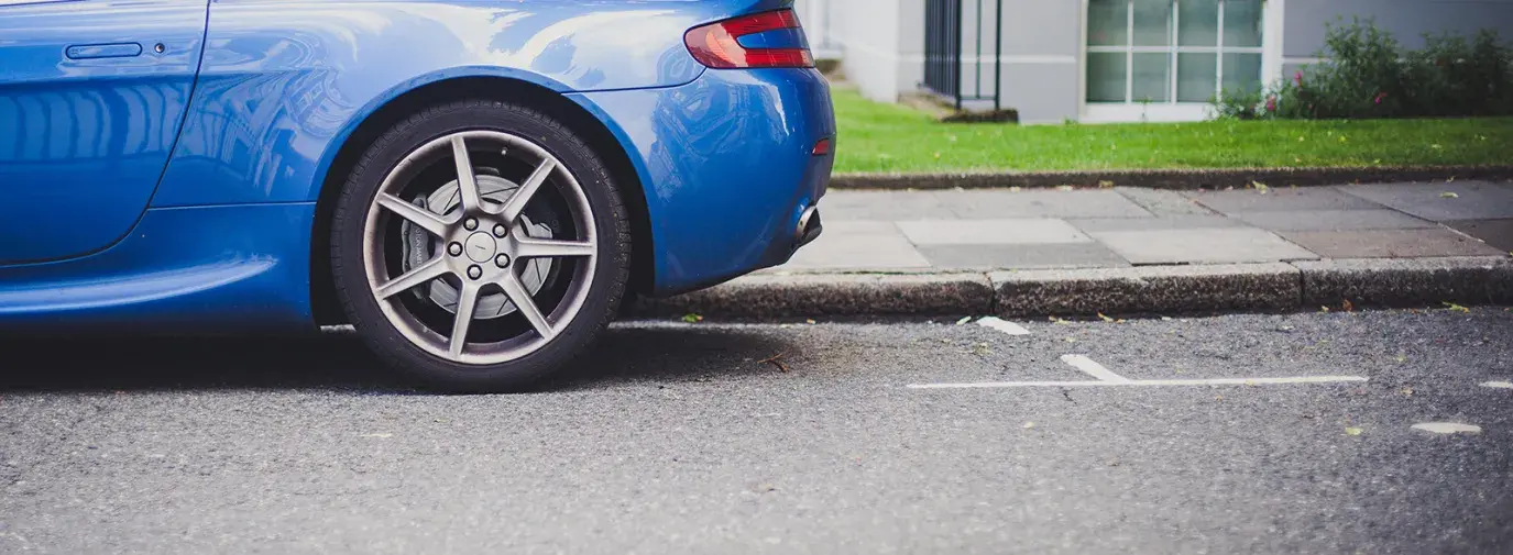 Image: blue car in parking spot. Topic: Reduce Your Carbon Footprint