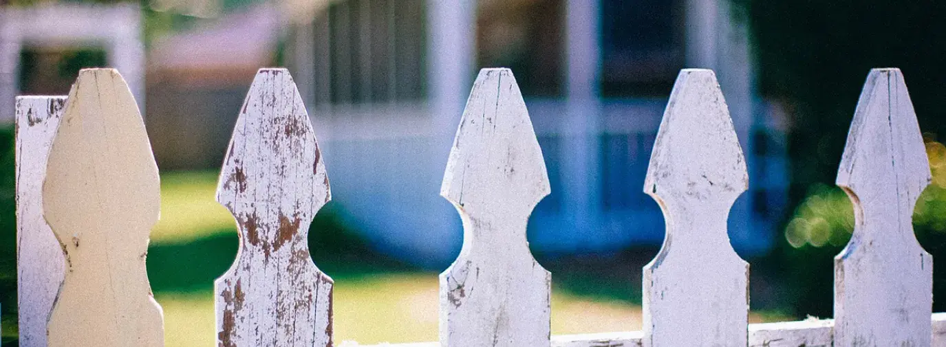Image: picket fence in front of a home. Topic: Mortgages from Responsible Banks and CDFIs