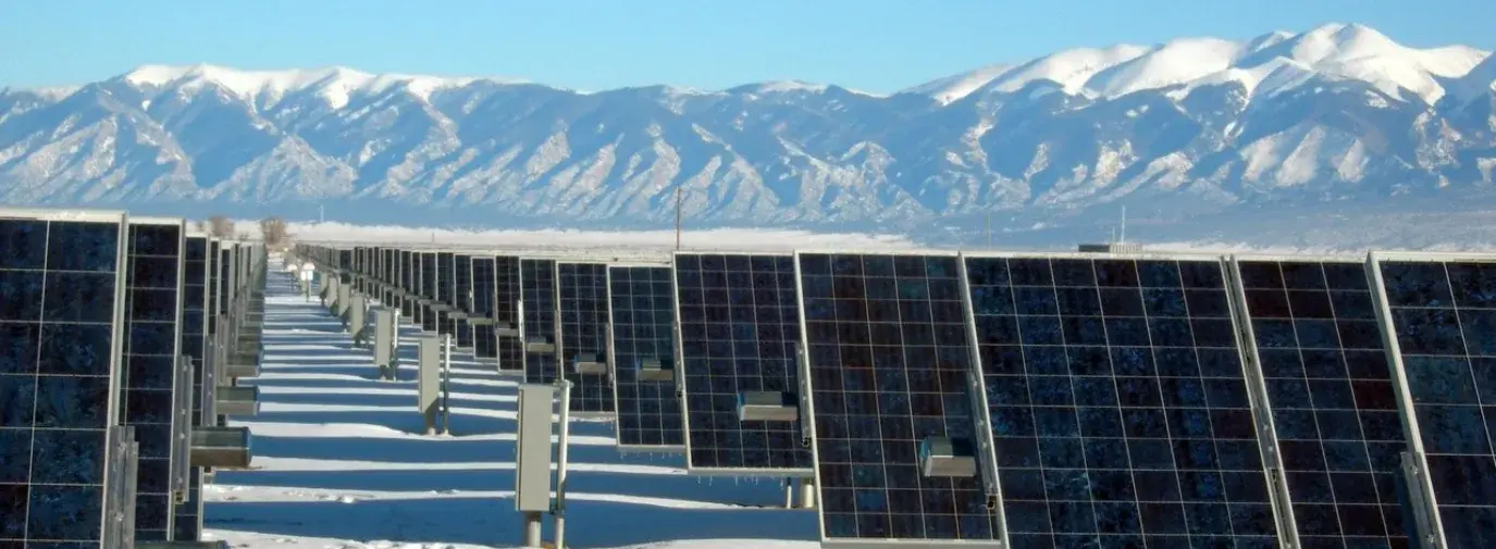 Image: solar panels in a field with snow-capped mountains beyond. Title: Solar Power Leases: Avoid the Big Initial Costs