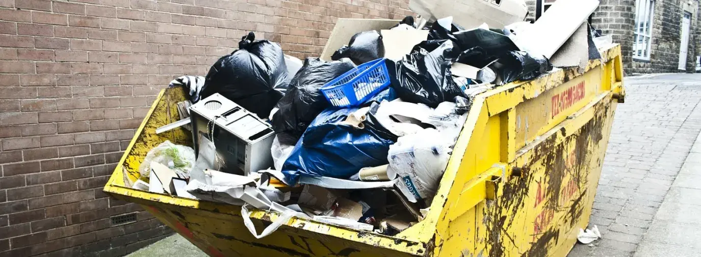Image: full dumpster. Title: Going Zero Waste at Our Green Festivals