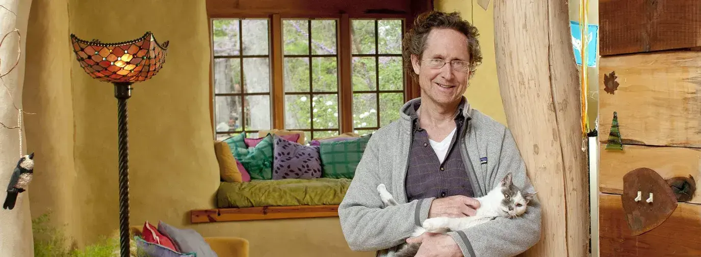 Bill Hutchins with his cat in his sunroom