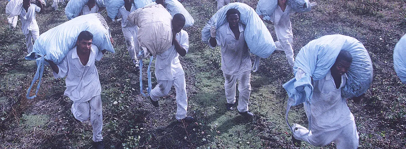 Image: prisoners haul bags through a field. Title: On Sale Now: Prison Labor