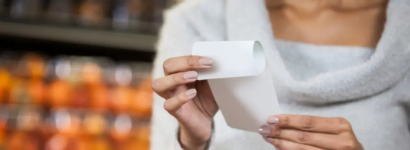 Image: woman holding paper receipt Topic: Skip the Slip to reduce store receipts