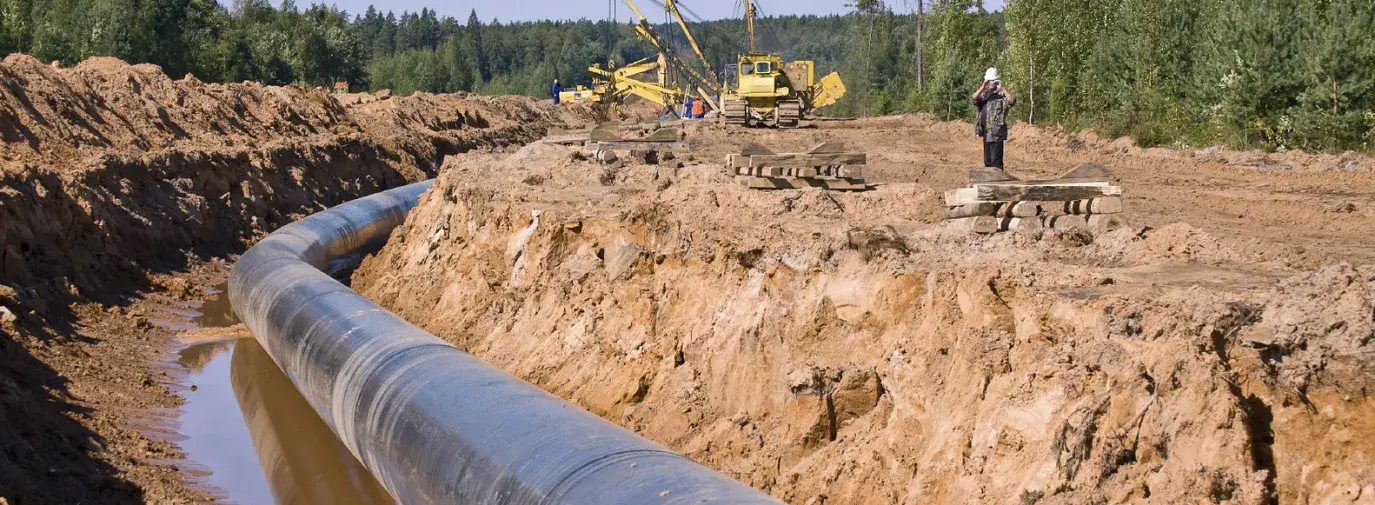workers construct gas pipeline over groundwater