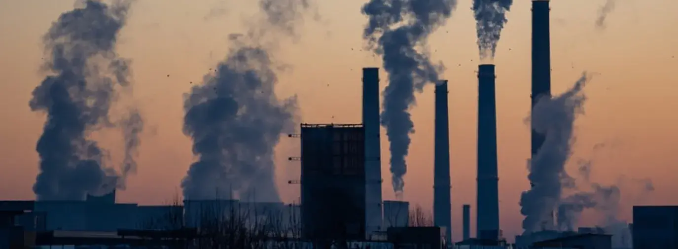 energy plants emitting clouds of pollution against sunset 