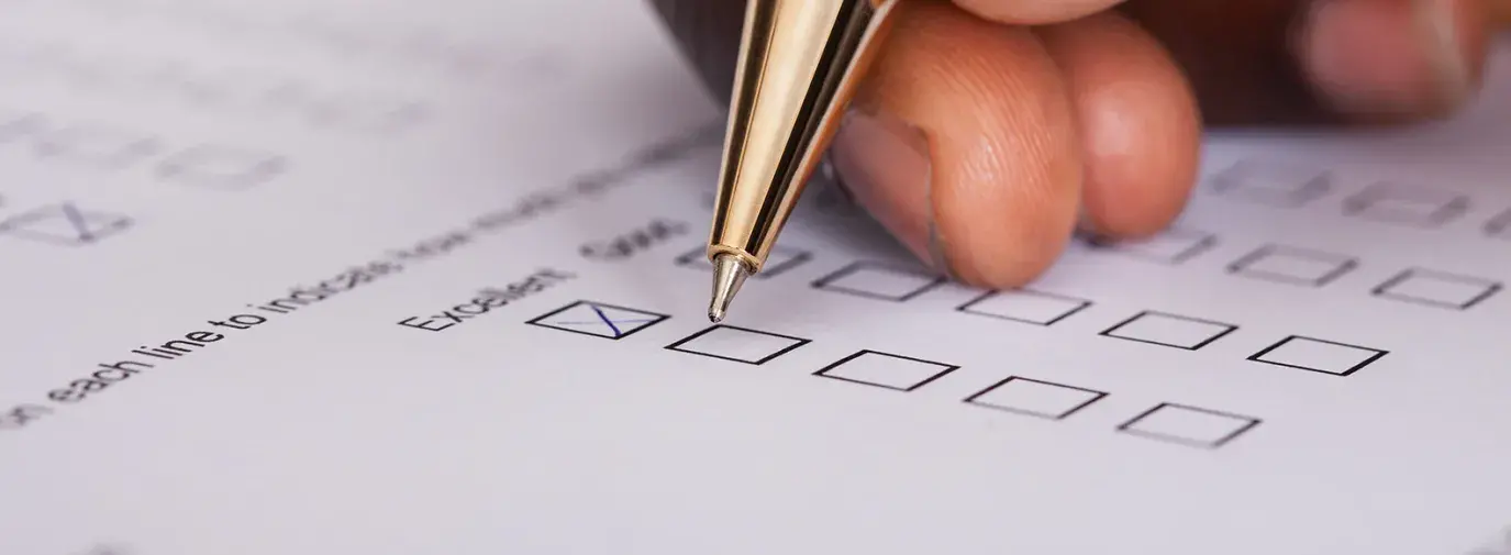 macro shot of a hand holding a gold pen, marking boxes on a sheet of paper, as the dollar tree shareholders did
