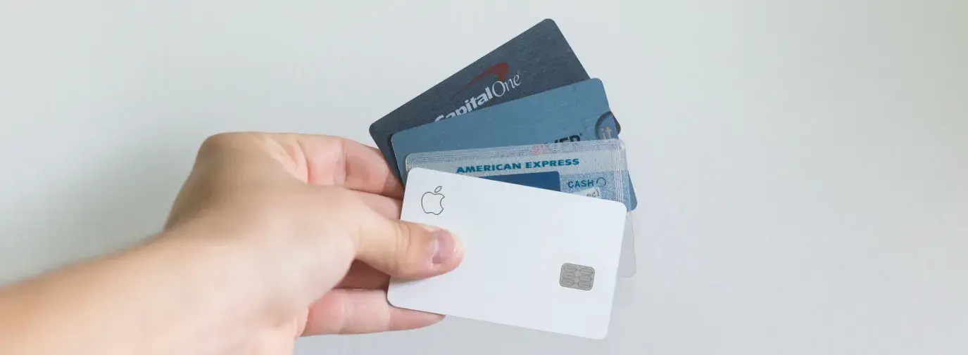 Image: hand holding several credit cards. Topic: Green America credit card.