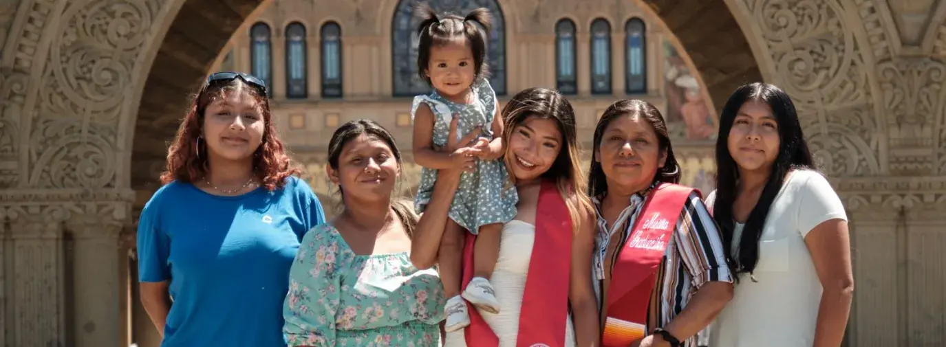 Brenda lvarez-Lagunas standing with her family members celebrating her graduation. Everyone is smiling at the camera.