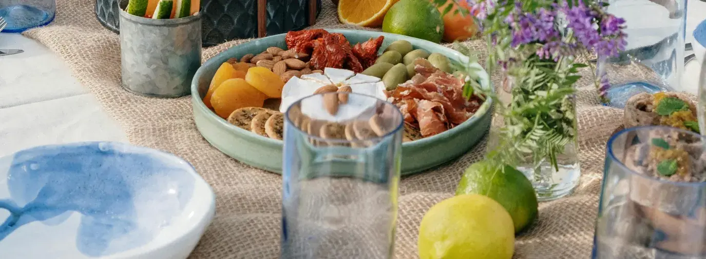 A spread of vegetables, herbs, fruit on a set table