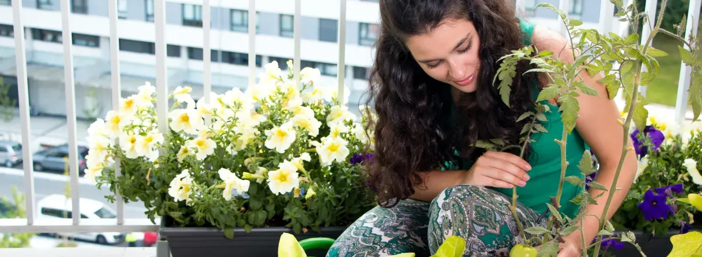 woman growing food in containers on balcony