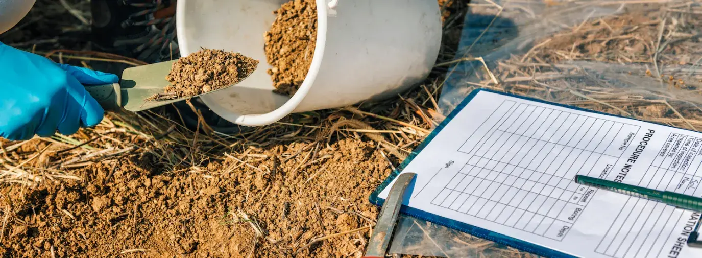 person adding soil to bucket for soil testing in climate victory garden