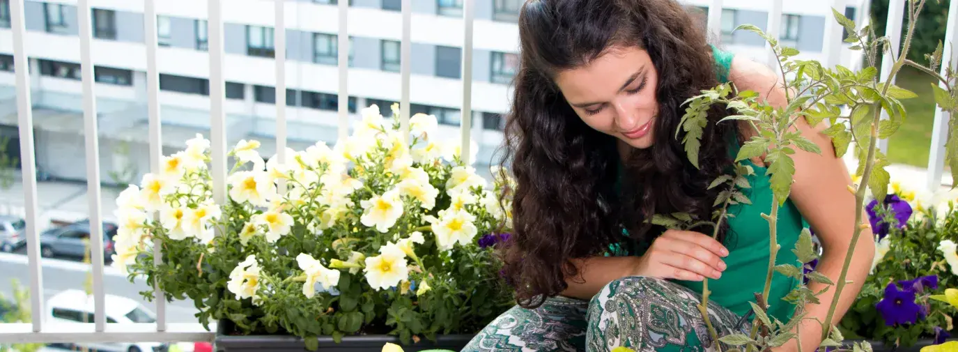 woman growing plants on balcony
