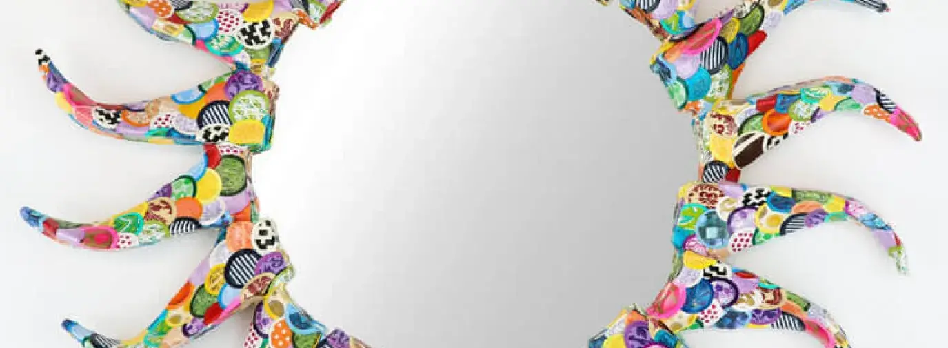 A round mirror decorated with papier-mâché in the shape of a sun. Mirrors Decorated.