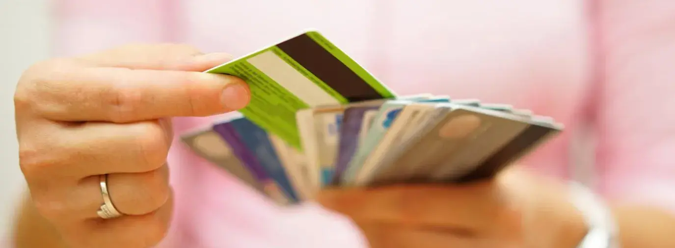 Image: person holding multiple credit cards. Topic: Find A Socially Responsible Credit Card