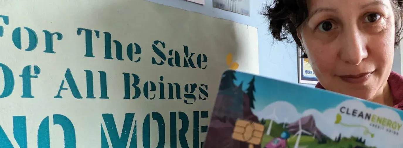 Image: Woman holding a card that reads "clean energy"