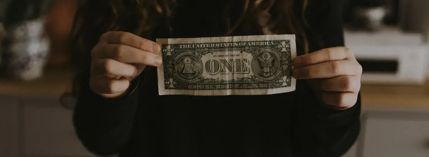 Image: person holding dollar bill. Topic: socially responsible finance